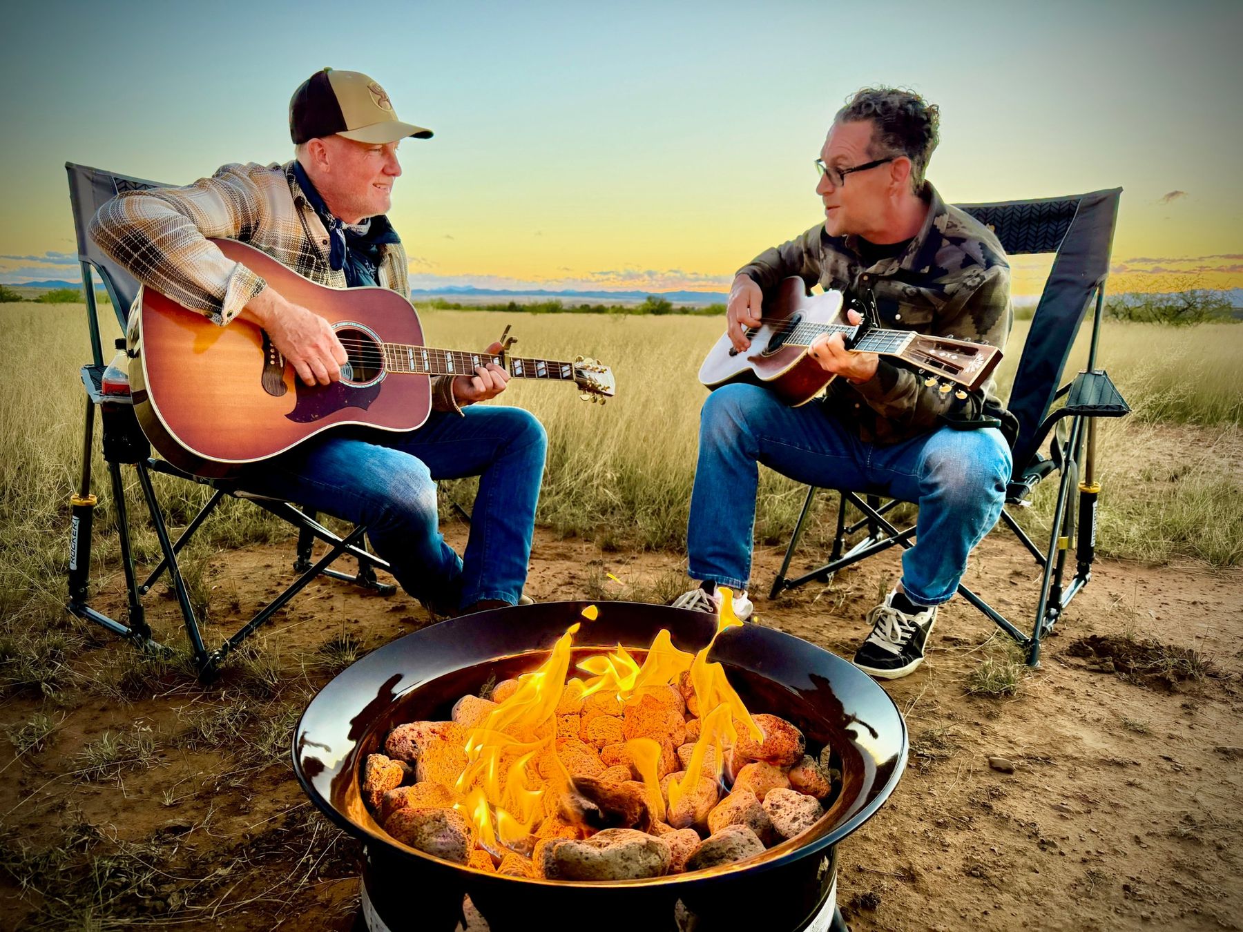 Acoustic guitars around a fire at dusk